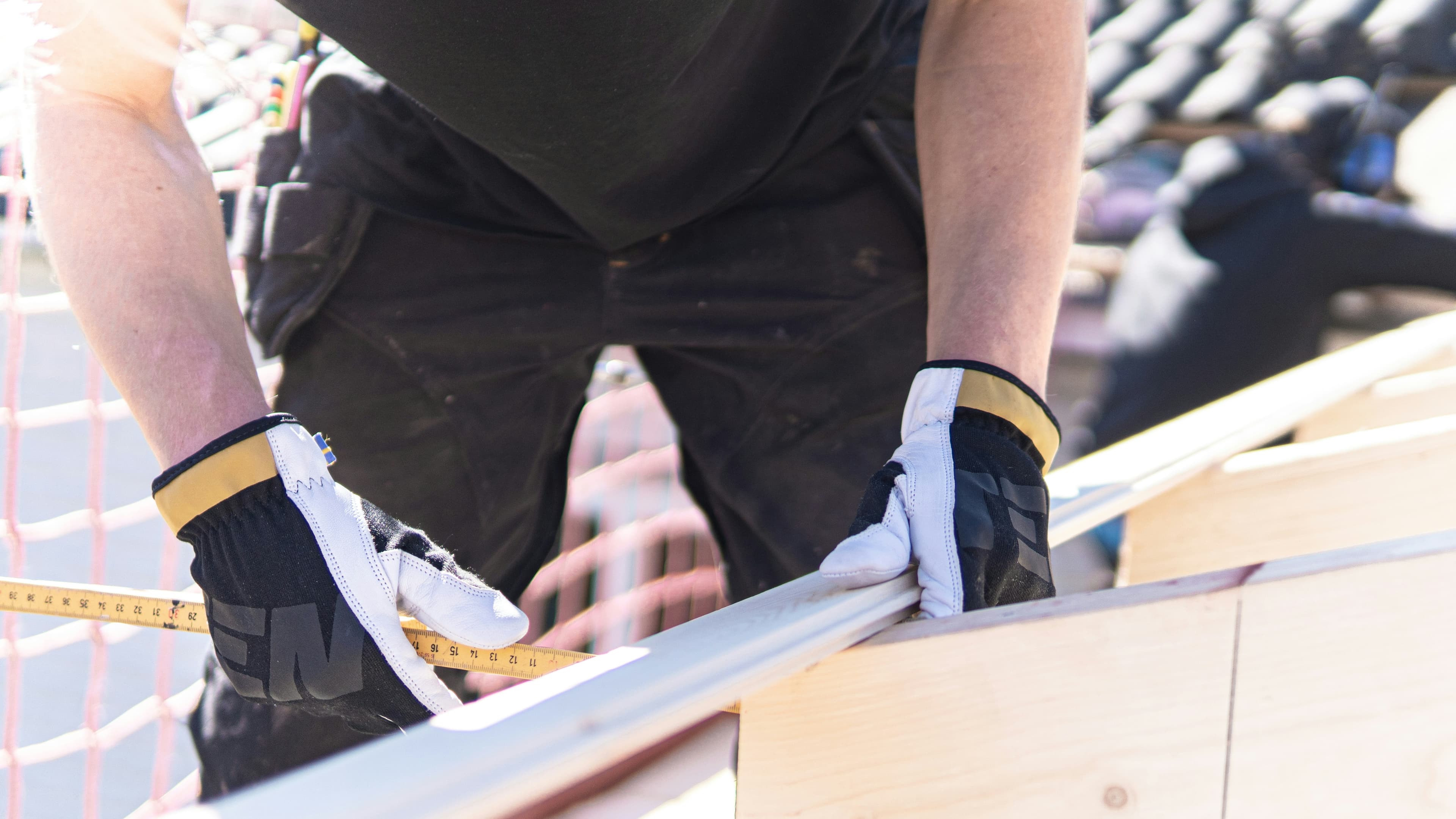 Roofing professional measuring material during repair work